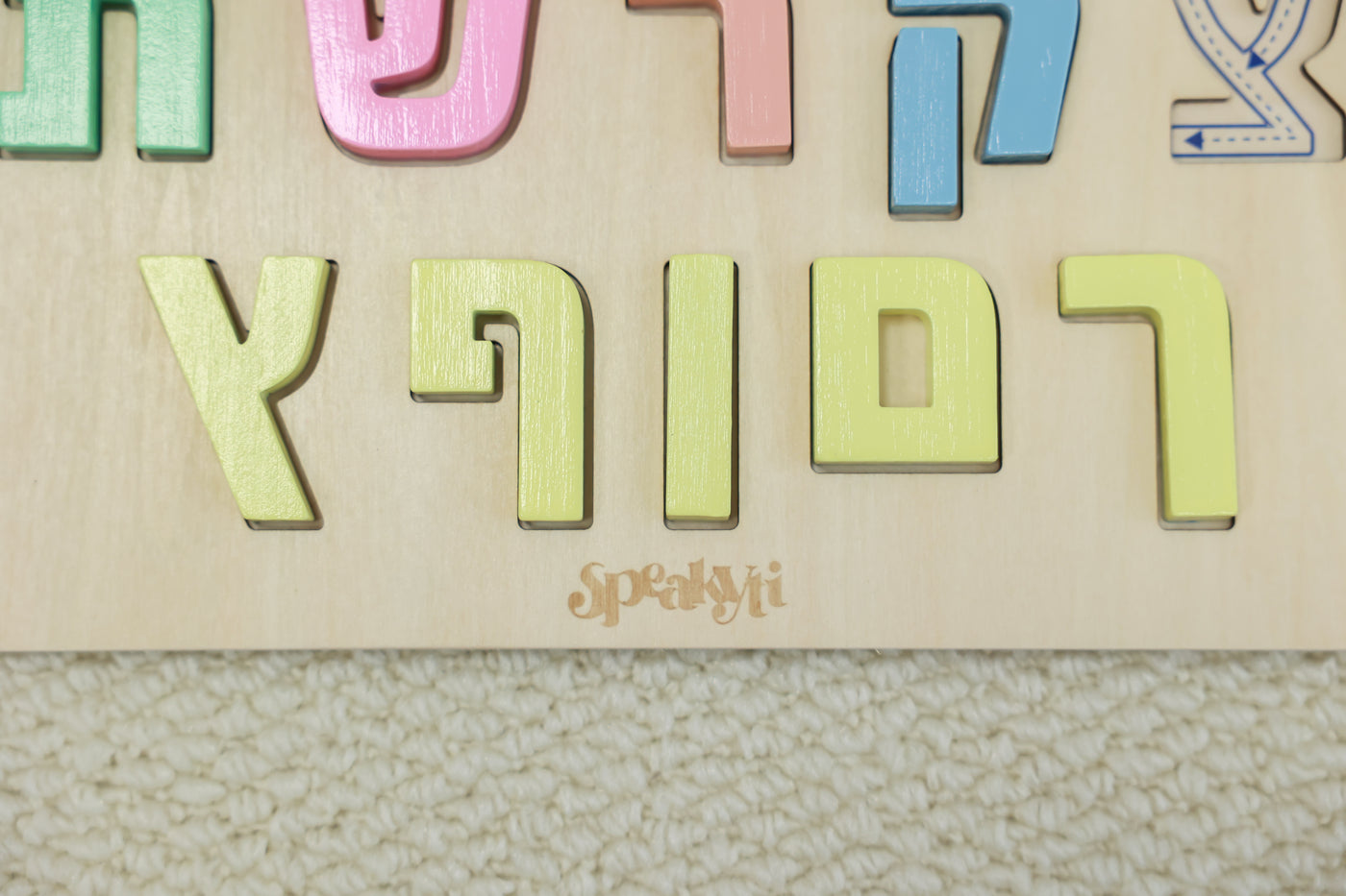 Hebrew wooden puzzle letter close-up. Engraved directional arrows showing correct Hebrew writing stroke order, ages 3+