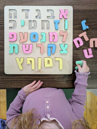 Child sorting Hebrew wooden alphabet puzzle pieces. 27-piece Montessori alef bet set with all 22 letters and 5 sofiot, designed by a speech therapist, ages 3+